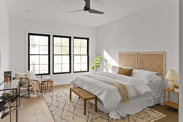 bedroom with ceiling fan, baseboards, and wood finished floors