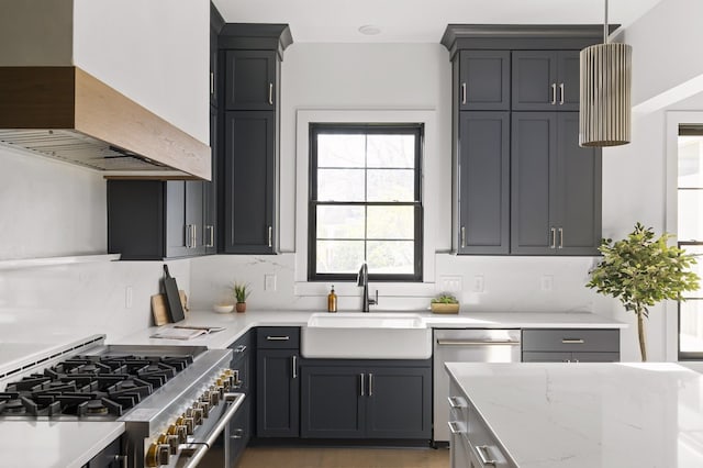 kitchen featuring custom exhaust hood, stainless steel appliances, tasteful backsplash, a sink, and light stone countertops