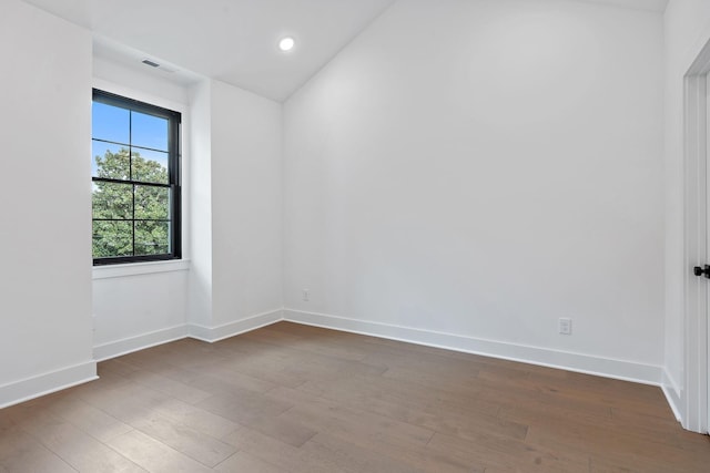 unfurnished room with recessed lighting, wood finished floors, visible vents, and baseboards