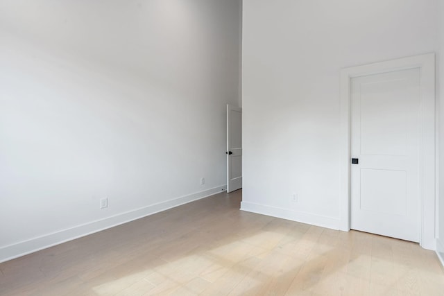 unfurnished room with light wood-style flooring and baseboards