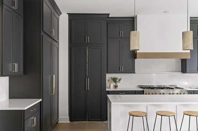 kitchen featuring light countertops, a breakfast bar, backsplash, and range