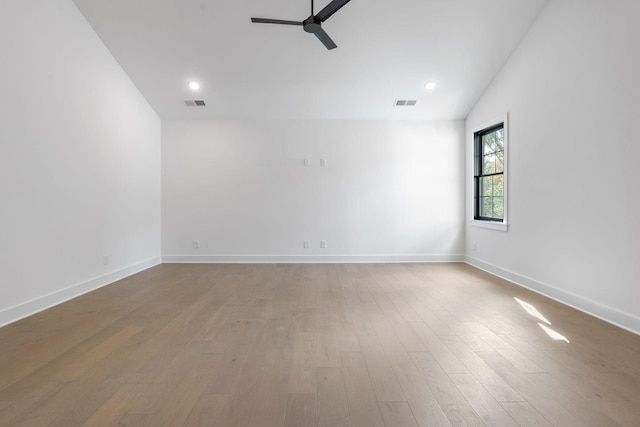 spare room featuring ceiling fan, visible vents, and wood finished floors