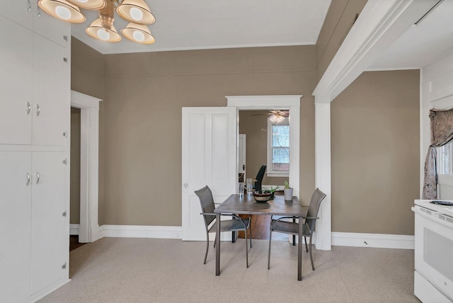 dining room featuring an inviting chandelier, light floors, and baseboards