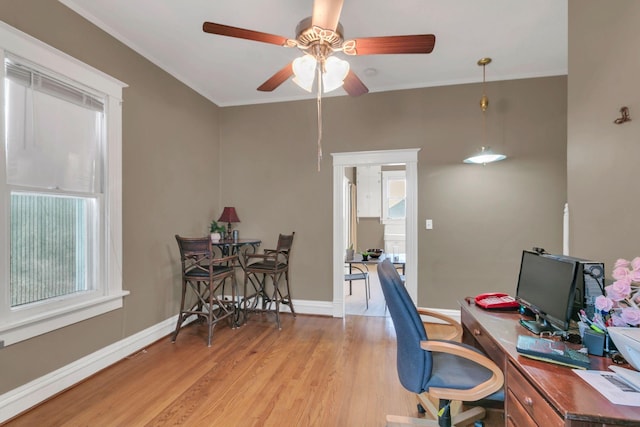 home office featuring baseboards, crown molding, light wood-style floors, and a ceiling fan