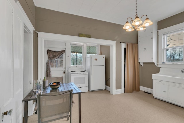 kitchen featuring visible vents, decorative light fixtures, an inviting chandelier, white cabinets, and white appliances