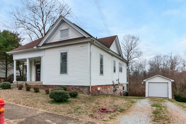 view of front facade featuring an outbuilding, driveway, covered porch, central AC, and a garage