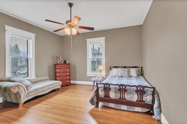 bedroom featuring a ceiling fan, baseboards, and light wood finished floors