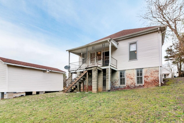 rear view of property with stairway and a lawn