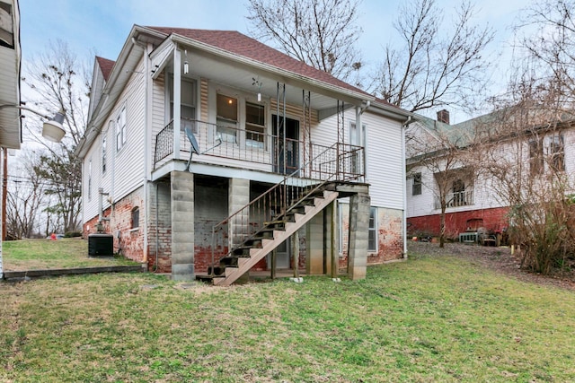 back of house with a shingled roof, stairway, a porch, central AC, and a lawn