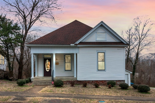 view of front of house featuring covered porch and a shingled roof