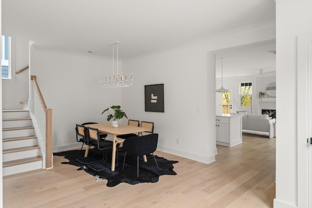 dining area featuring light wood-type flooring, stairs, and ornamental molding