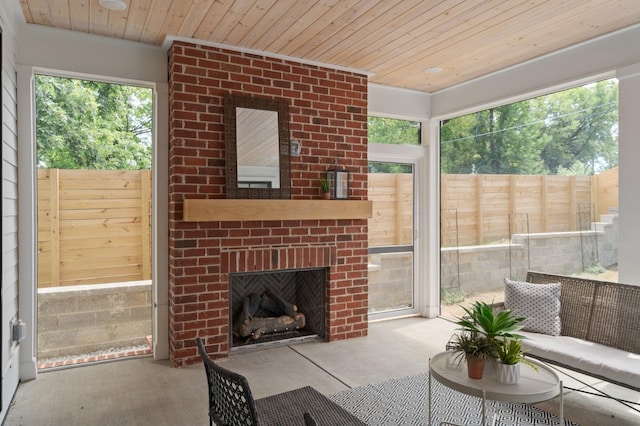 living room with an outdoor brick fireplace, wooden ceiling, and wood finished floors