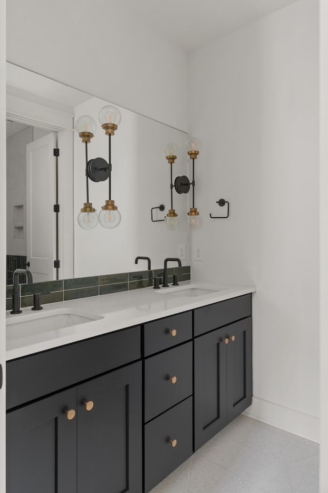 bathroom featuring double vanity, a sink, and baseboards