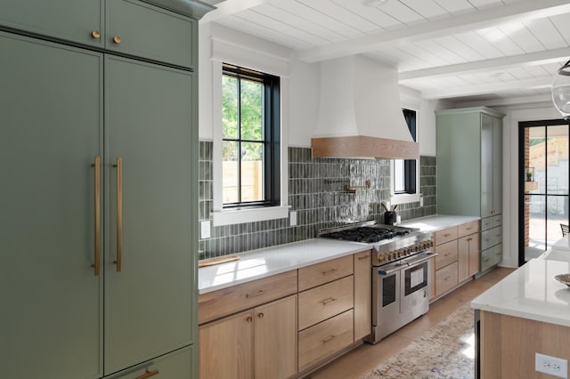 kitchen featuring premium appliances, beam ceiling, custom range hood, decorative backsplash, and green cabinetry