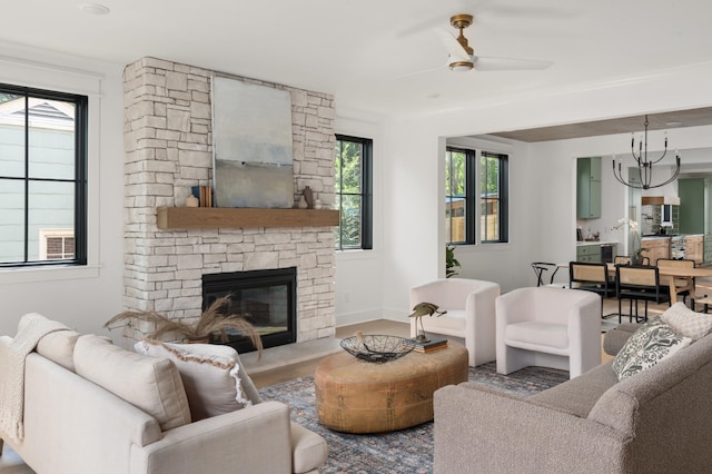 living room with ceiling fan, a wealth of natural light, a fireplace, and wood finished floors