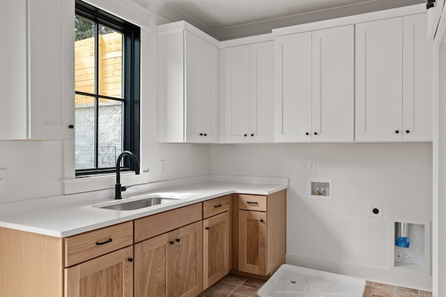 laundry area featuring light tile patterned floors, hookup for a washing machine, cabinet space, a sink, and electric dryer hookup