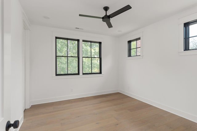 spare room with ceiling fan, light wood-style flooring, visible vents, and baseboards