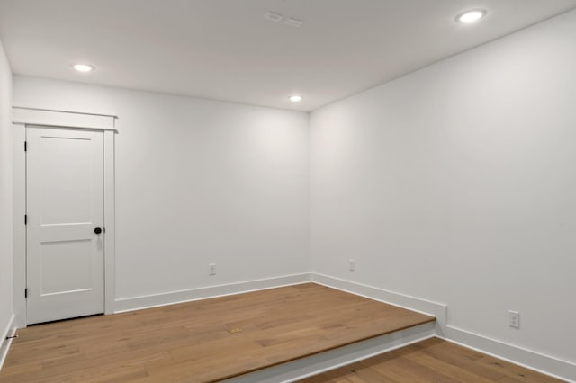 unfurnished room featuring light wood-type flooring, baseboards, and recessed lighting