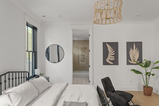 bedroom with baseboards, wood finished floors, connected bathroom, and crown molding