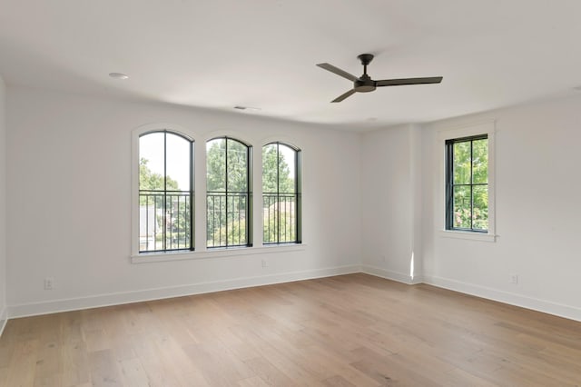 empty room with light wood-style floors, visible vents, baseboards, and ceiling fan