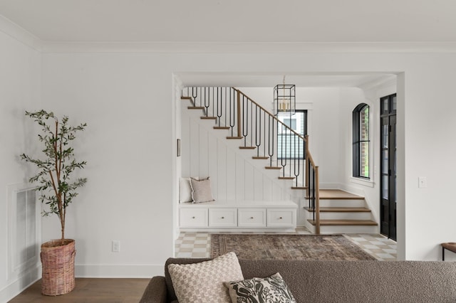 interior space with baseboards, visible vents, ornamental molding, and wood finished floors