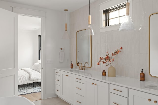 ensuite bathroom with connected bathroom, a sink, and double vanity