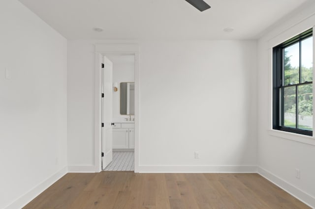 unfurnished room with baseboards, light wood-style floors, and a healthy amount of sunlight