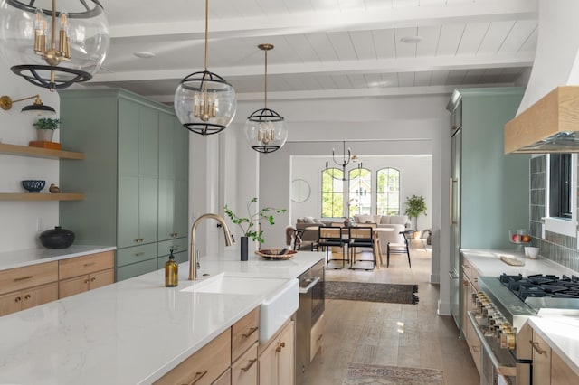 kitchen featuring beam ceiling, custom exhaust hood, light wood finished floors, stainless steel stove, and a sink