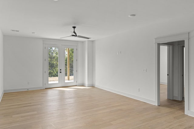 spare room with light wood finished floors, ceiling fan, baseboards, and french doors