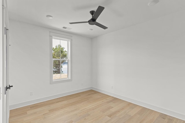 spare room with light wood finished floors, baseboards, visible vents, and ceiling fan