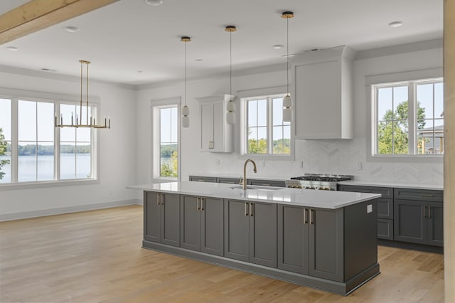 kitchen with light countertops, a sink, range, and gray cabinetry