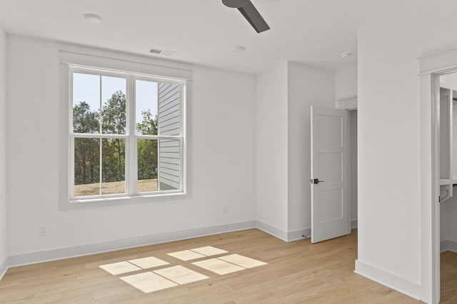 unfurnished bedroom with a ceiling fan, light wood-type flooring, visible vents, and baseboards