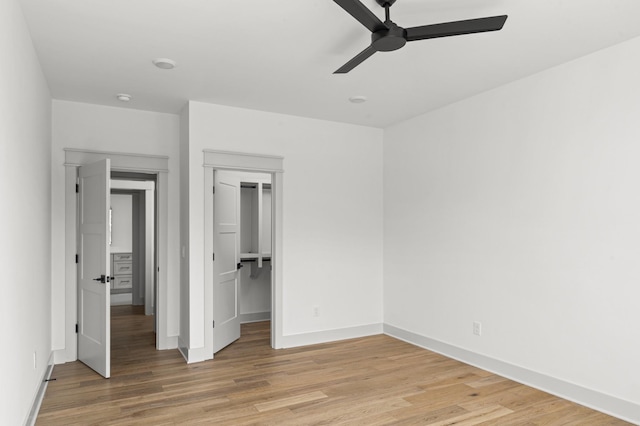 unfurnished bedroom featuring light wood-type flooring, a ceiling fan, baseboards, and a closet