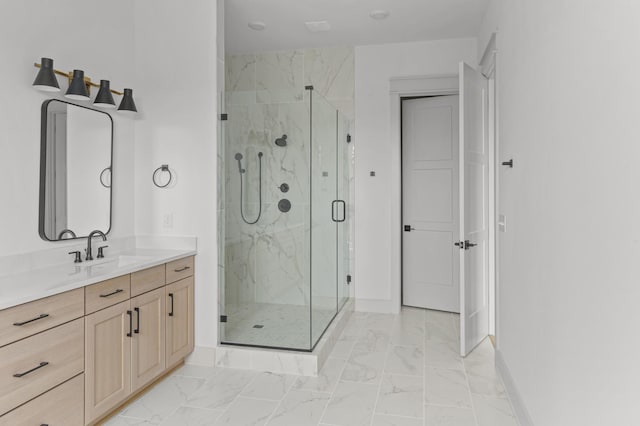 full bath featuring marble finish floor, a marble finish shower, vanity, and baseboards