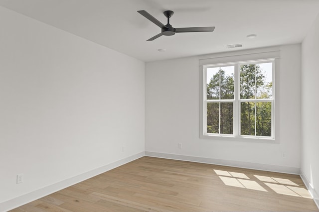 spare room featuring light wood-style floors, visible vents, baseboards, and ceiling fan