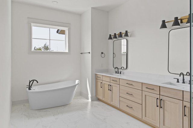 full bathroom featuring marble finish floor, double vanity, a sink, and baseboards