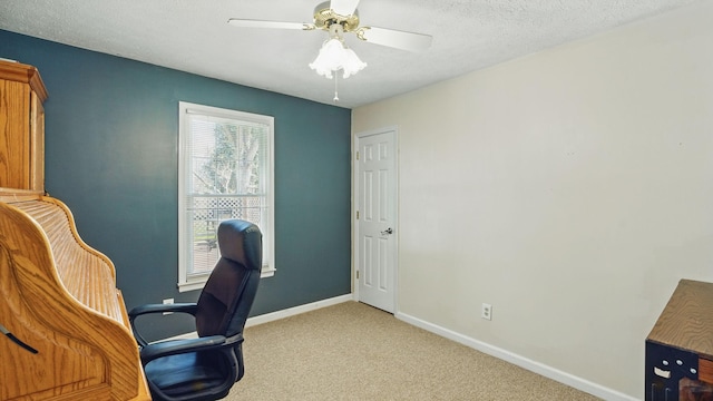 office featuring a ceiling fan, light carpet, a textured ceiling, and baseboards