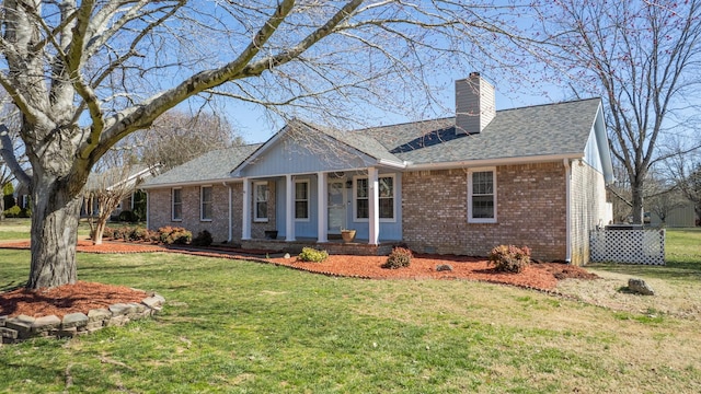 view of front facade with a shingled roof, a chimney, crawl space, a front yard, and brick siding