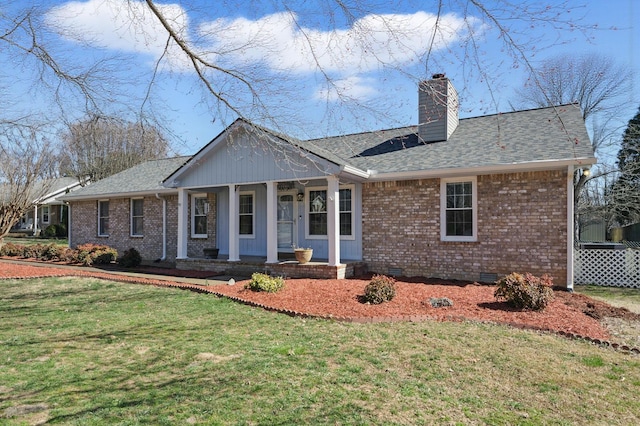 view of front of property with a chimney, crawl space, a front yard, a porch, and brick siding