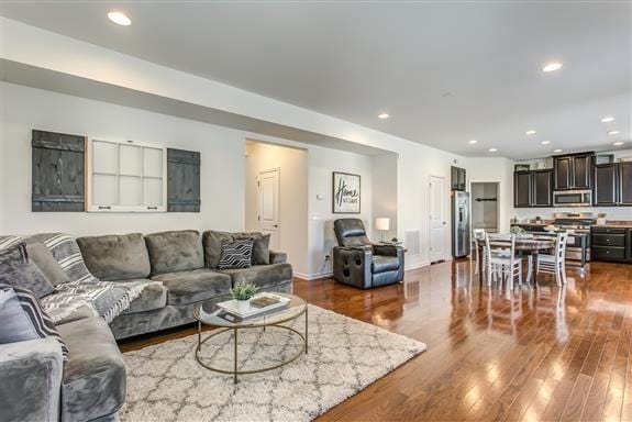 living room with baseboards, dark wood finished floors, visible vents, and recessed lighting