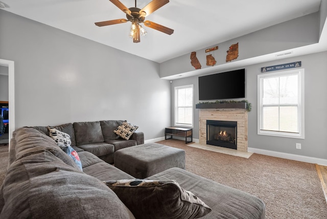 carpeted living area with lofted ceiling, a fireplace with flush hearth, baseboards, and a ceiling fan