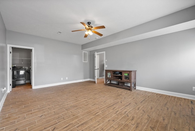 unfurnished living room featuring a ceiling fan, baseboards, visible vents, and wood finished floors