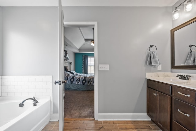 bathroom featuring ensuite bathroom, a garden tub, vanity, baseboards, and wood tiled floor