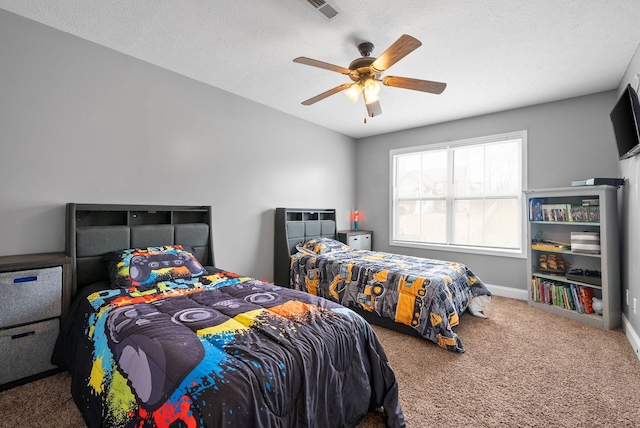 bedroom with a textured ceiling, carpet flooring, visible vents, a ceiling fan, and baseboards