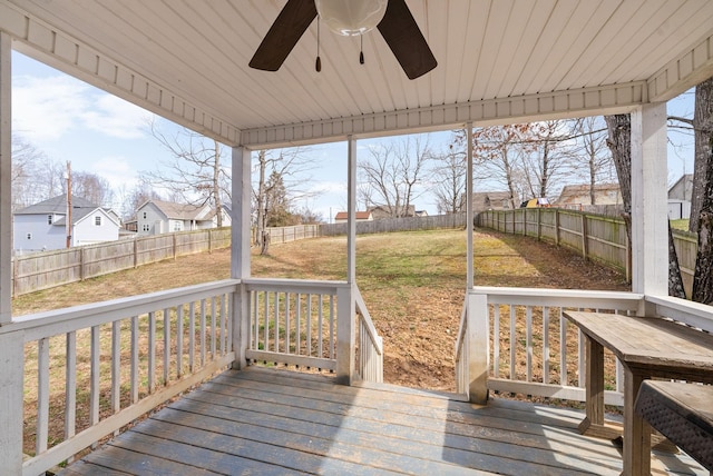 deck with a ceiling fan, a residential view, a fenced backyard, and a yard