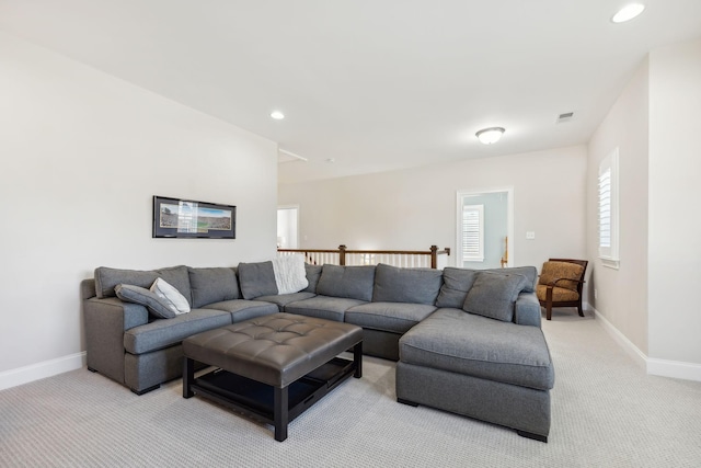 living area with recessed lighting, light colored carpet, visible vents, and baseboards