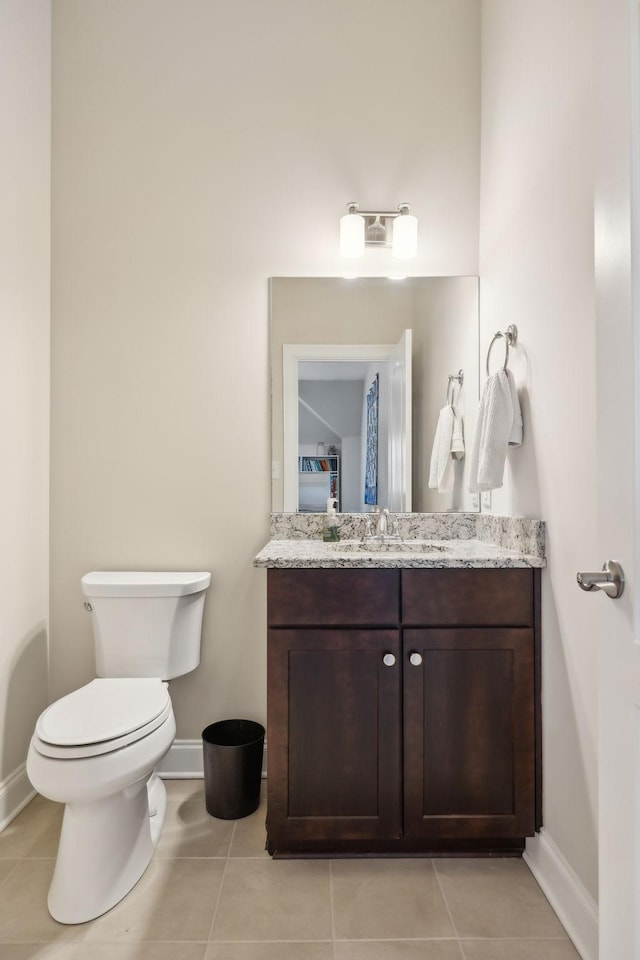 bathroom with toilet, tile patterned flooring, baseboards, and vanity