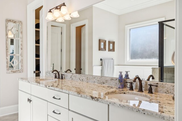 full bath featuring crown molding, a sink, baseboards, and double vanity