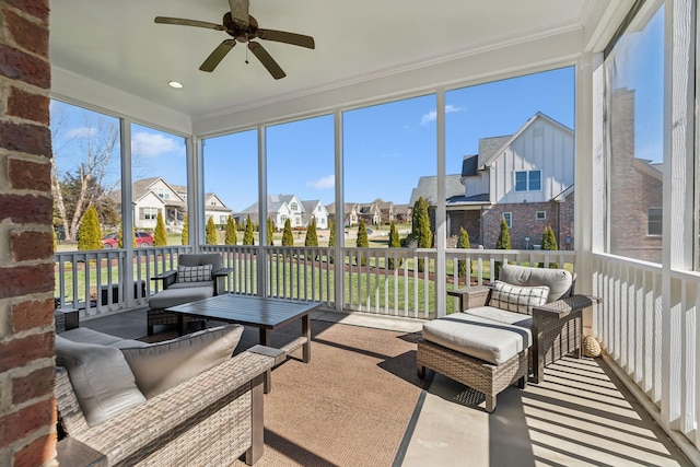 sunroom with ceiling fan and a residential view