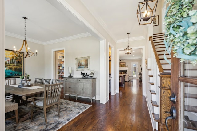 foyer entrance with crown molding, baseboards, stairs, dark wood-style floors, and an inviting chandelier